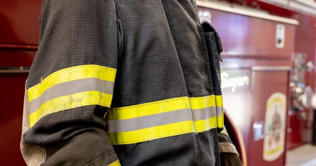 close-up image of a fireman walking past a firetruck