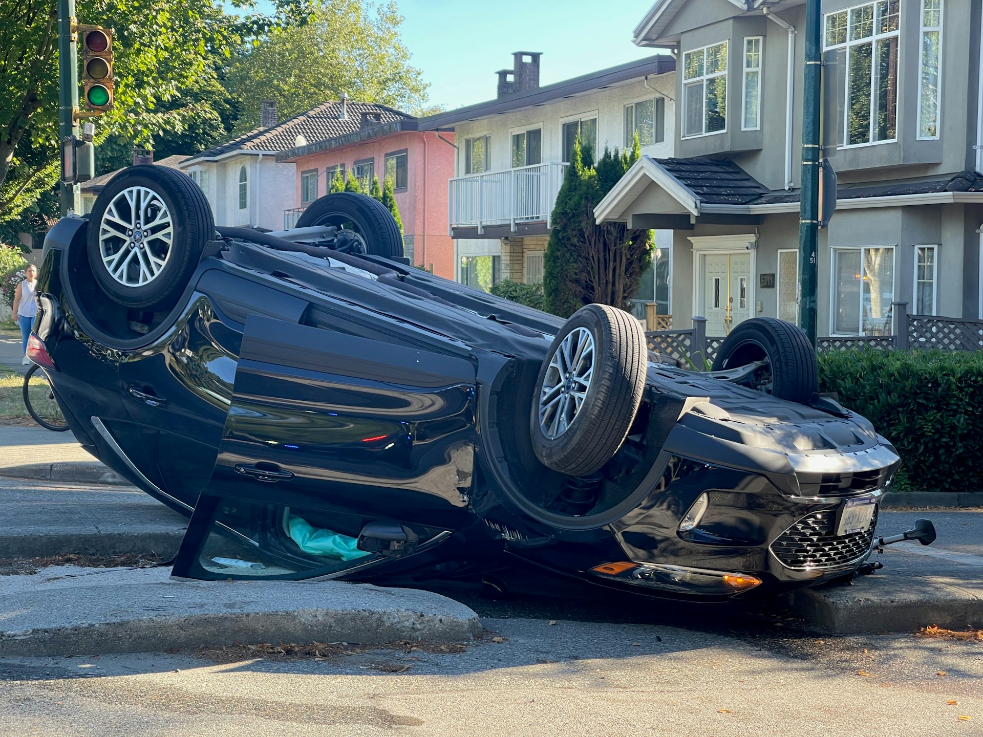 An overturned car on the street, with its wheels in the air, indicating a serious accident scene.